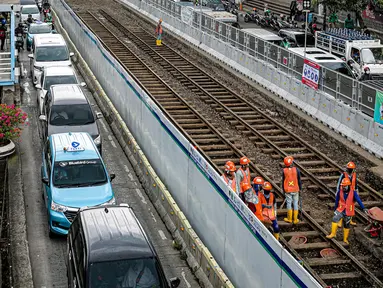 Pekerja melakukan pembongkaran aspal yang menutup jalur trem pada masa kolonial Belanda di lokasi proyek MRT Jakarta fase 2 di kawasan Jalan Gajah Mada, Jakarta, Rabu (9/11/2022). Rel Trem Kembali ditemukan pada proyek pembangunan MRT Jakarta Fase 2A Glodok-Kota, seberang Mall Gajah Mada. (Liputan6.com/Faizal Fanani)