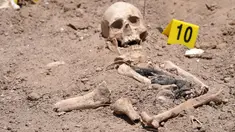 Sisa-sisa jenazah manusia yang digali dari kuburan massal oleh otoritas Irak, tergeletak di tanah dekat kota selatan Najaf, pada 14 Mei 2022. Kuburan massal itu, pertama kali ditemukan pada April tahun ini, diyakini menampung puluhan orang yang kemungkinan besar tewas di bawah mendiang diktator Saddam Hussein, kata seorang pejabat. (AFP)