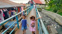 Anak-anak bermain dengan girang meskipun aroma busuk dari sampah yang menggenang di Sungai Tawar, anak Sungai Musi Palembang ini mengganggu pernapasan (Liputan6.com / Nefri Inge)