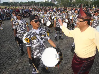 Menhub Budi Karya Sumadi bergoyang mengikuti irama musik pemain marching band acara puncak Hari Perhubungan Nasional di Lapangan Silang Monas, Jakarta, Minggu (17/9). Menhub Budi terlihat mengenakan baju khas Palembang. (Liputan6.com/Immanuel Antonius)