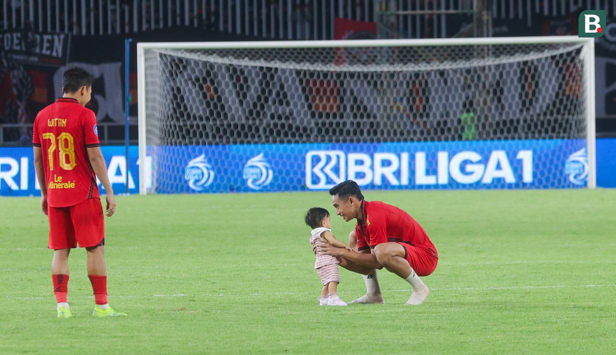 Pemain Macan Kemayoran, Rizky Ridho, bermain dengan anak Witan Sulaeman setelah pertandingan Persija Jakarta kontra Persik Kediri pada laga BRI Liga 1 di Stadion Pakansari, Jakarta, Minggu (1/12/2024). (Bola.com/M Iqbal Ichsan)