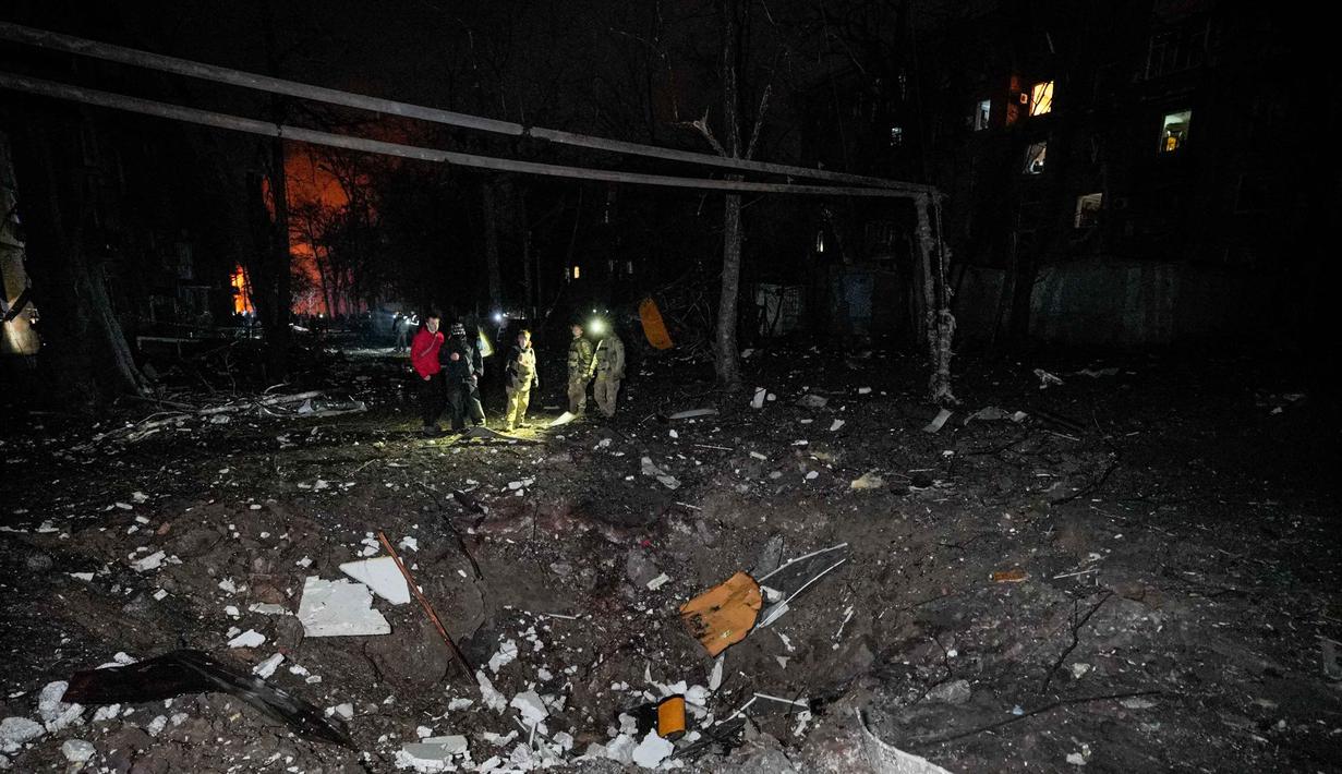 Ledakan juga terdengar di Kyiv, ibu kota Ukraina, serta di wilayah barat Lviv. Tampak dalam foto, polisi mengamati kawah akibat serangan Rusia di lingkungan perumahan di Kryvyi Rih, Ukraina, Kamis, 8 Januari 2026. (AP Photo/Mykola Myrnyi)
