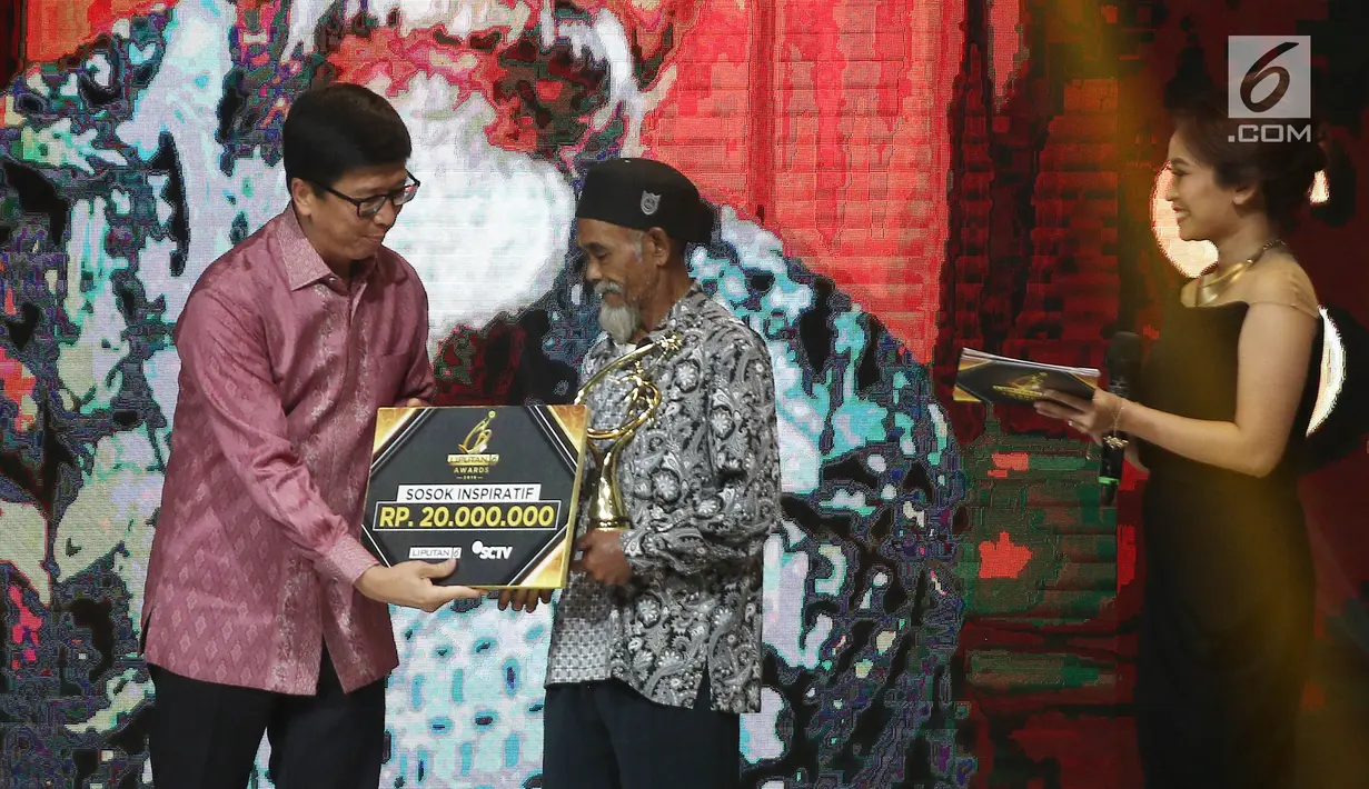 Wakil Direktur Utama PT Elang Mahkota Teknologi Tbk (EMTEK) Sutanto Hartono memberikan piala kepada Sadiman dalam kategori lingkungan hidup pada Liputan6 Awards 2018 di SCTV Tower, Jakarta, Minggu (20/5). (Liputan6.com/Herman Zakharia)