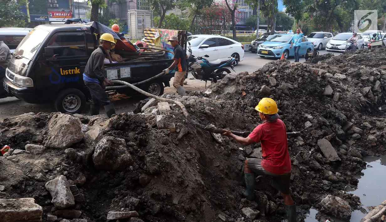 Pekerja membongkar saluran air (drainase) yang akan diperbaiki di jalan Hayam Wuruk, Jakarta Pusat, Selasa (20/11). Perbaikan dan pelebaran saluran air ini untuk mengantisipasi terjadinya banjir di kawasan tersebut saat hujan. (Liputan6.com/Johan Tallo)