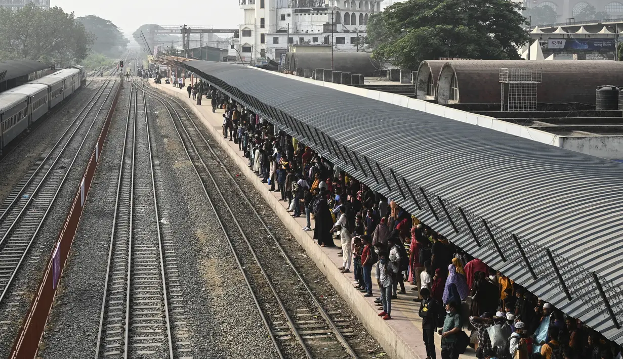 <p>Orang-orang yang pulang untuk merayakan Idul Fitri, yang menandai berakhirnya bulan suci Ramadhan, menunggu di peron untuk naik kereta api di stasiun kereta Bandara Dhaka di Dhaka pada 29 April 2022. (AFP/Munir uz Zaman)</p>