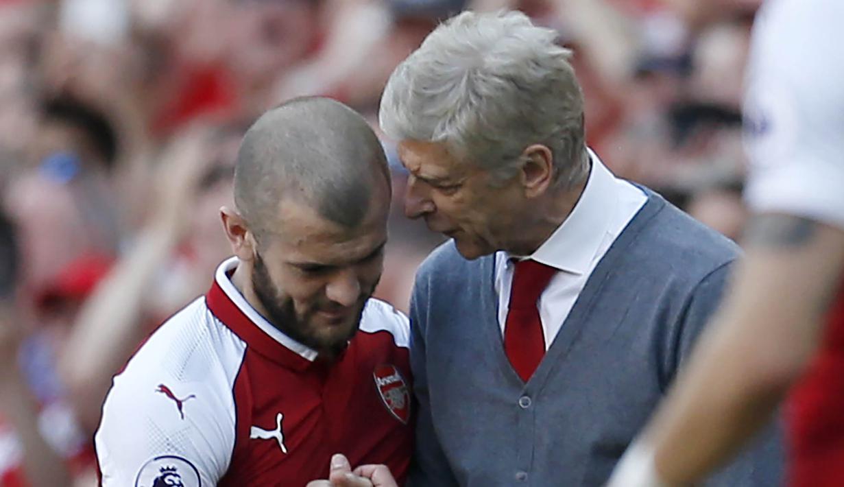 Pelatih Arsenal, Arsene Wenger, berbincang dengan Jack Wilshere saat perpisahan di Stadion Emirates (6/5/2018). Selama 22 tahun membesut Arsenal, Wenger telah mempersembahkan 17 gelar dan 704 Kemenangan. (AFP/Ian Kington)