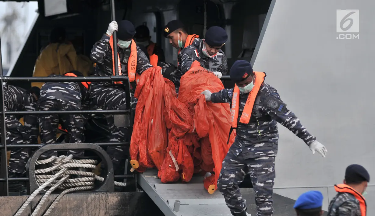 Anggota TNI menurunkan kantong plastik dari KRI Torani saat tiba di posko evakuasi JICT 2, Tanjung Priok, Jakarta, Kamis (1/11). Tim SAR gabungan kembali menemukan potongan tubuh korban dan puing pesawat Lion Air JT 610. (Merdeka.com/Iqbal S. Nugroho)