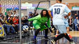 Mantan kiper Kolombia, Rene Higuita berusaha menghalau bola yang akan masuk ke gawangnya dalam laga bertajuk Legends Soccer Match untuk merayakan ulang tahun Diego Maradona di American Dream Mall, East Rutherford, New Jersey, pada 30 Oktober 2025. (AFP/Kena Betancur)