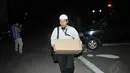 Dengan membawa sebuah kardus, seorang penyidik keluar meninggalkan gedung Kemenag, Jakarta, Kamis (22/5/14). (Liputan6.com/Johan Tallo)