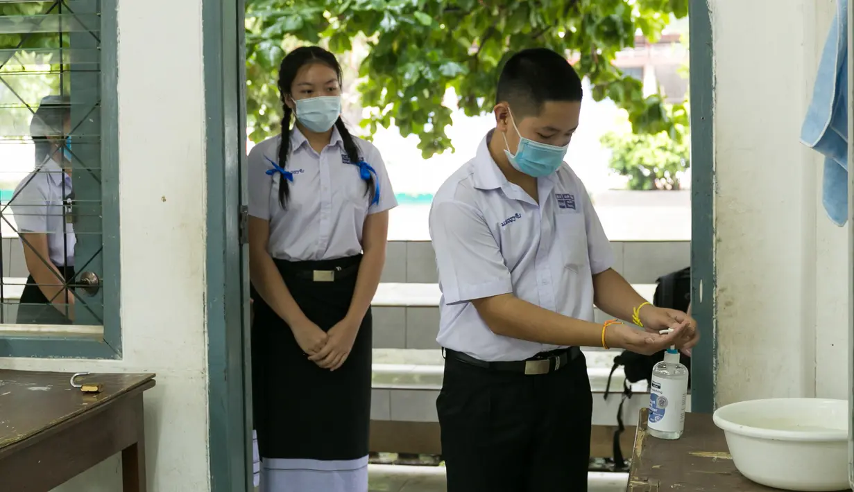 Para siswa yang mengenakan masker mengantre untuk mencuci tangan di sebuah sekolah di Vientiane, Laos, Selasa (19/5/2020). Siswa tingkat akhir sekolah dasar, menengah pertama, dan menengah di Laos sudah mulai bersekolah sejak 18 Mei 2020. (Xinhua/Kaikeo Saiyasane)