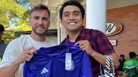 Aditya Nugraha berfoto bersama dengan bek Timnas Argentina Nicolas Tagliafico usai mendapatkan tanda tangannya di Bandara Internasional I Gusti Ngurah Rai. (Alit Binawan/Bola.com)