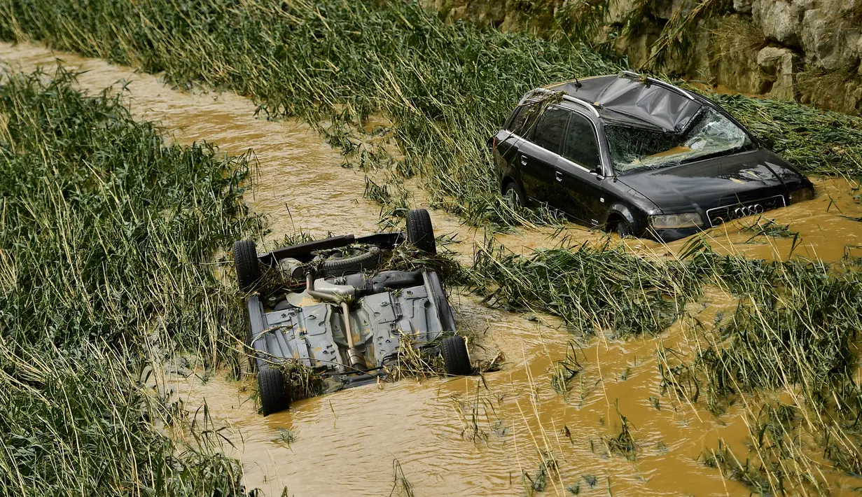 Sejumlah mobil rusak dan terendam air setelah banjir bandang menerjang Tafalla, Spanyol, Selasa (9/7/2019). Menurut perkiraan Badan Meteorologi Spanyol, AEMET, hujan deras masih akan terjadi hingga Rabu besok. (AP Photo/Alvaro Barrientos)