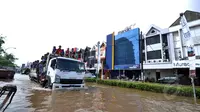 Sejumlah warga menerobos genangan banjir dengan menumpang sebuah truk di kawasan Kelapa Gading, Jakarta, Selasa (10/2/2015). Menurut Kadin DKI Jakarta, kerugian akibat banjir mencapai Rp 1,5 triliun tiap harinya.(Liputan6.com/Faizal Fanani)
