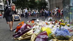 Seorang wanita bereaksi usai meletakkan bunga sebagai penghormatan bagi korban penyanderaan di Kafe Lindt, Sidney, Australia (16/12/2014). Tiga orang tewas dan empat terluka dalam penyanderaan yang terjadi selama lebih dari 16 jam. (REUTERS/Jason Reed)