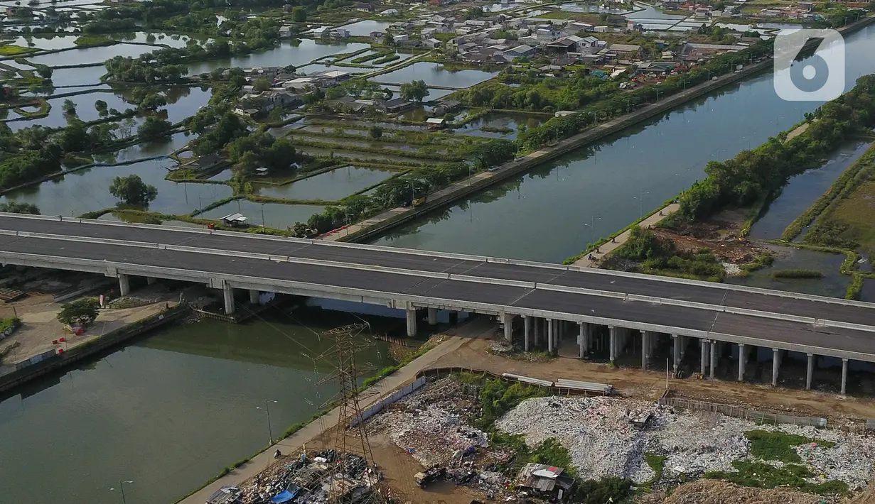 Foto udara pembangunan Jalan Tol Cibitung-Cilincing (JTCC)  seksi 4 di Marunda, Jakarta Utara, Selasa (8/11/2022). Setelah kontruksi rampung akhir November 2022, maka beberapa pengujian akan dilakukan sebelum dioperasikan. (Liputan6.com/Herman Zakharia)