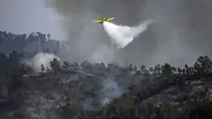 Sebuah pesawat pemadam kebakaran menjatuhkan air di atas api di Odeceixe, selatan Portugal, Selasa (8/8/2023). Ratusan petugas pemadam kebakaran berusaha memadamkan api yang berkobar di Portugal selatan yang telah menghanguskan ribuan hektare lahan dan menyebabkan sekitar 1.400 orang dievakuasi untuk berjaga-jaga. (Patricia DE MELO MOREIRA/AFP)