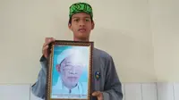 Salah seorang santri Pondok Pesantren Jagasatru Kota Cirebon memegang foto mendiang Ayip Muh. Foto (Liputan6.com / Panji Prayitno)