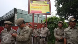 Petugas Satpol PP berjaga di depan tempat ibadah jemaah Ahmadiyah yang disegel di Jalan Raya Muchtar Sawangan, Depok, Jawa Barat, Jumat (24/2). (Liputan6.com/Immanuel Antonius)