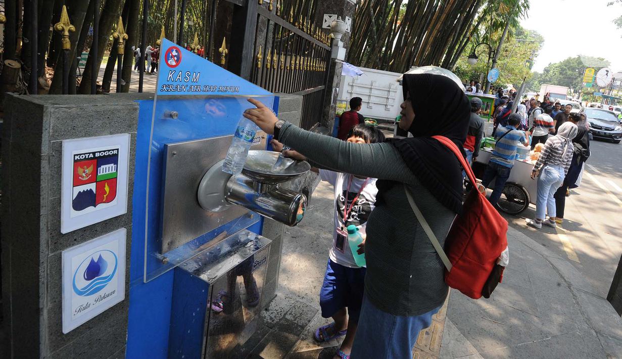 Warga mengisi air ke botol dari Keran Air Siap Minum (KASM) yang terpasang di dekat Pintu 2 Kebun Raya Bogor, Jawa Barat, Minggu (6/10/2019). Pemkot Bogor melalui PDAM Tirta Pakuan membuat KASM untuk menekan angka konsumsi botol dan gelas plastik. (merdeka.com/Arie Basuki)