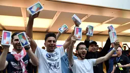 Pelanggan pertama menunjukkan iPhone X setelah ia membelinya di showroom Apple di Sydney, Australia (3/11). Apple iPhone X mulai dijual di Australia dengan antrian panjang di luar toko Apple. (AFP Photo/Saeed Khan)