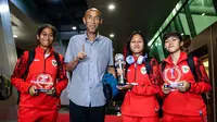 Pemain Timnas Indonesia, Laita Roati (kiri), Viny Silfianus (kedua kanan), Reva Octaviani (kanan), dan pelatih Satoru Mochizuki (kedua kiri) berpose dengan membawa trofi Piala AFF Wanita 2024 dan penghargaan individu (kiper terbaik dan pemain terbaik) saat mendarat di Gedung VVIP Terminal 3 Bandara Soekarno Hatta, Tangerang, Jumat (06/12/2024). (Bola.com/Bagaskara Lazuardi)
