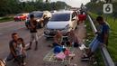 <p>Sejumlah pemudik menanti waktu berbuka puasa Ramadhan sambil beristirahat di KM 102 ruas Tol Cikopo-Palimanan, Subang, Jawa Barat, Kamis (28/4/2022). Padatnya sejumlah rest area di sepanjang jalan tol Trans Jawa membuat pemudik memanfaatkan bahu jalan untuk berbuka puasa dan istirahat sejenak. (Liputan6.com/Herman Zakharia)</p>