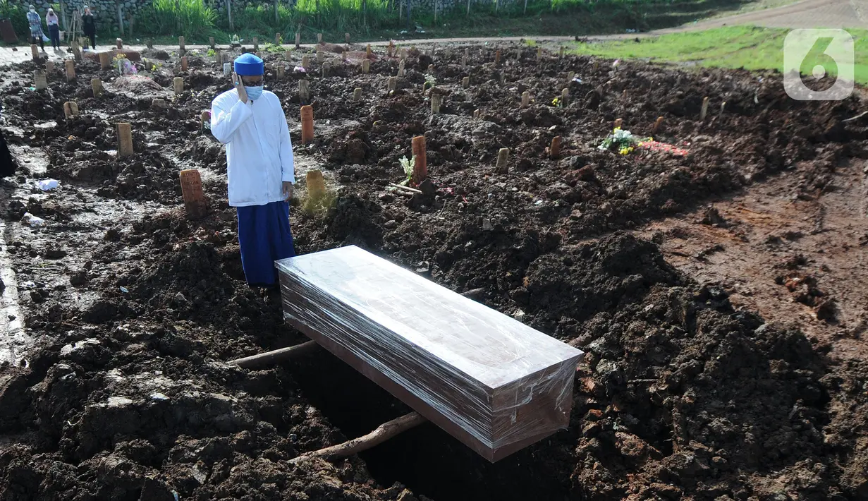 Keluarga mengadzani korban COVID-19 warga Tangerang Selatan yang meninggal di Bandung di TPU Jombang, Tangerang Selatan, Banten, Senin (21/6/2021). Pasca-Lebaran, kasus kematian akibat COVID-19 di Tangerang Selatan meningkat rata-rata 20 persen. (merdeka.com/Arie Basuki)