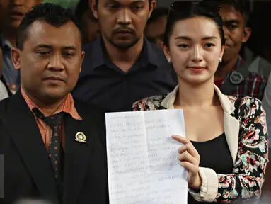 Pedangdut Zaskia Gotik menunjukkan isi suratnya untuk Presiden Jokowi usai menjalani pemeriksaan di Polda Metro Jaya, Jakarta, Rabu (30/3).  Zaskia memilih berkirim surat kepada Jokowi untuk menyampaikan permintaan maaf. (Liputan6.com/Immanuel Antonius)