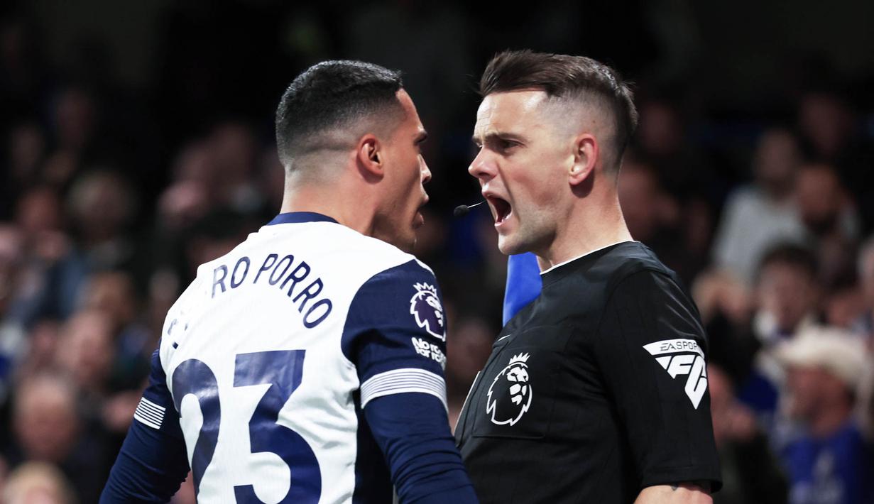 Pemain Tottenham Hotspur, Pedro Porro, bersitegang dengan wasit Craig Pawson saat melawan Chelsea dalam laga pekan 30 Premier League di Stadion Stamford Bridge, Jumat (4/4/2025) dini hari WIB. (AP Photo/Ian Walton)
