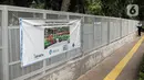 Spanduk pemberitahuan proyek pembangunan pagar dan pemasangan sensor jembatan tep terpasang pada pagar di Tebet Eco Park, Jakarta, Senin (12/12/2022). Pemprov DKI Jakarta melakukan pembatasan jumlah pengunjung taman dengan pembuatan sistem pendaftaran masuk pengunjung melalui JAKI sejak Juli 2022. (Liputan6.com/Faizal Fanani)