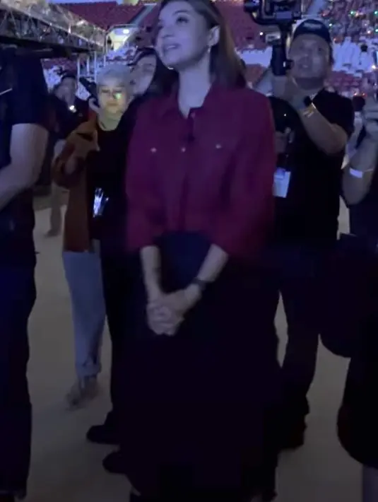 Najwa Shihab tampil dengan jaket warna merah maroon dipadukan skirt hitam dan bootsnya. (@najwashihab)