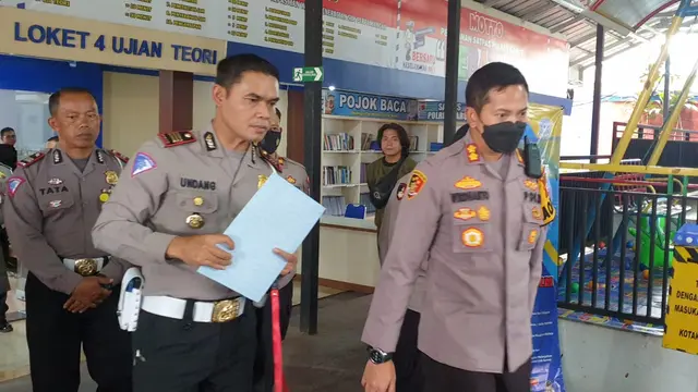 Kasatlantas Polres Garut AKP Undang Syarif Hidayat memberikan arahan dan penjelasan kepada Kapolres Garut AKBP Wirdhanto Hadicaksono dalam simulasi pembuatan SIM bagi warga. (Liputan6.com/Jayadi Supriadin)