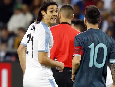 Megabintang timnas Argentina, Lionel Messi berbicara dengan penyerang timnas Uruguay, Edinson Cavani pada laga persahabatan di Stadion Bloomfield, Tel Aviv, Senin (18/11/2019). Messi dan Cavani sempat terlibat adu mulut di lapangan, ketika Argentina tertinggal 0-1. (Jack GUEZ / AFP)