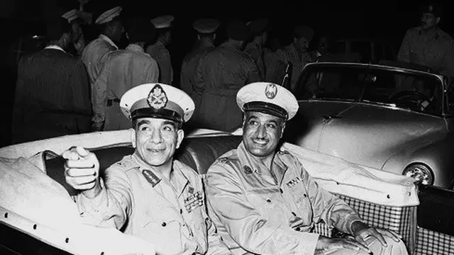 Nasser (kanan) dan Mohamed Naguib (kiri) selama perayaan menandai peringatan kedua revolusi 1952, Juli 1954. (Public Domain)