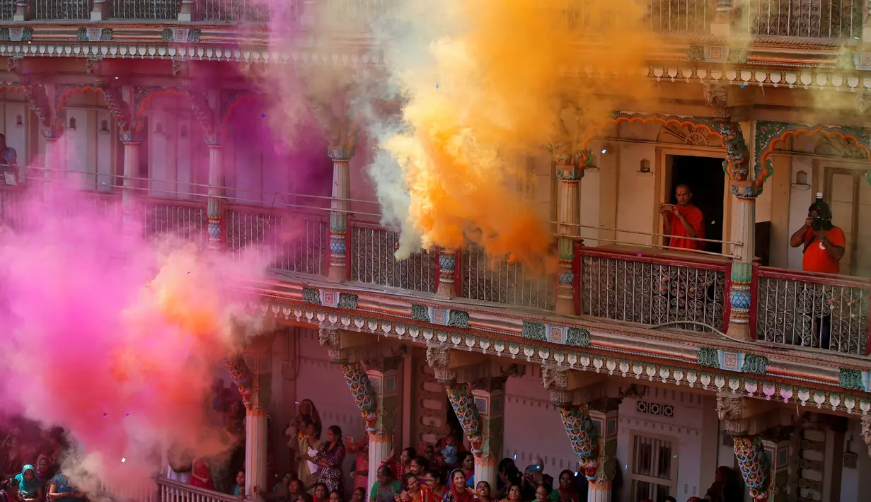 Pendeta Hindu mengambil foto kemeriahan perayaan Holi di sebuah kuil di Ahmedabad, India, Rabu (20/3). Holi juga menjadi libur nasional yang biasanya bertepatan dengan hari terakhir purnama dalam kalender Hindu. (REUTERS/Amit Dave)