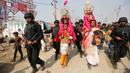 Petugas keamanan berjaga-jaga saat orang suci Hindu membawa anak-anak berpakaian seperti Dewa Rama dan Sita pada ritual Basant Panchami dalam festival tahunan Magh Mela di Allahabad, India, Senin (22/1). (AP Photo/Rajesh Kumar Singh)