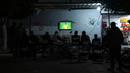 Warga Palestina menyaksikan siaran langsung pertandingan sepak bola Grup G Piala Dunia 2022 antara Brasil dengan Swiss yang dimainkan di Qatar di jalan di Rafah, Jalur Gaza, 28 November 2022. (AP Photo/Fatima Shbair)