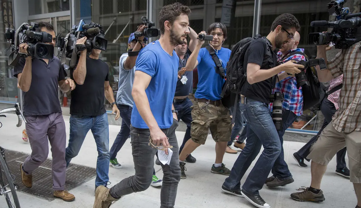 Usai dibebaskan, aktor Shia LaBeouf dikelilingi media saat meninggalkan Midtown Community Court di New York, Jumat (27/6/14). (REUTERS/Brendan McDermid)