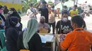 Petugas melayani warga penerima bantuan sosial tunai (BST) dari Kemensos di kawasan Kelurahan Kembangan, Meruya, Jakarta Barat, Minggu (25/07/2021). Penyaluran BST tersebut diperkirakan akan rampung pada 7 Agustus 2021 mendatang. (Liputan6.com/Herman Zakharia)