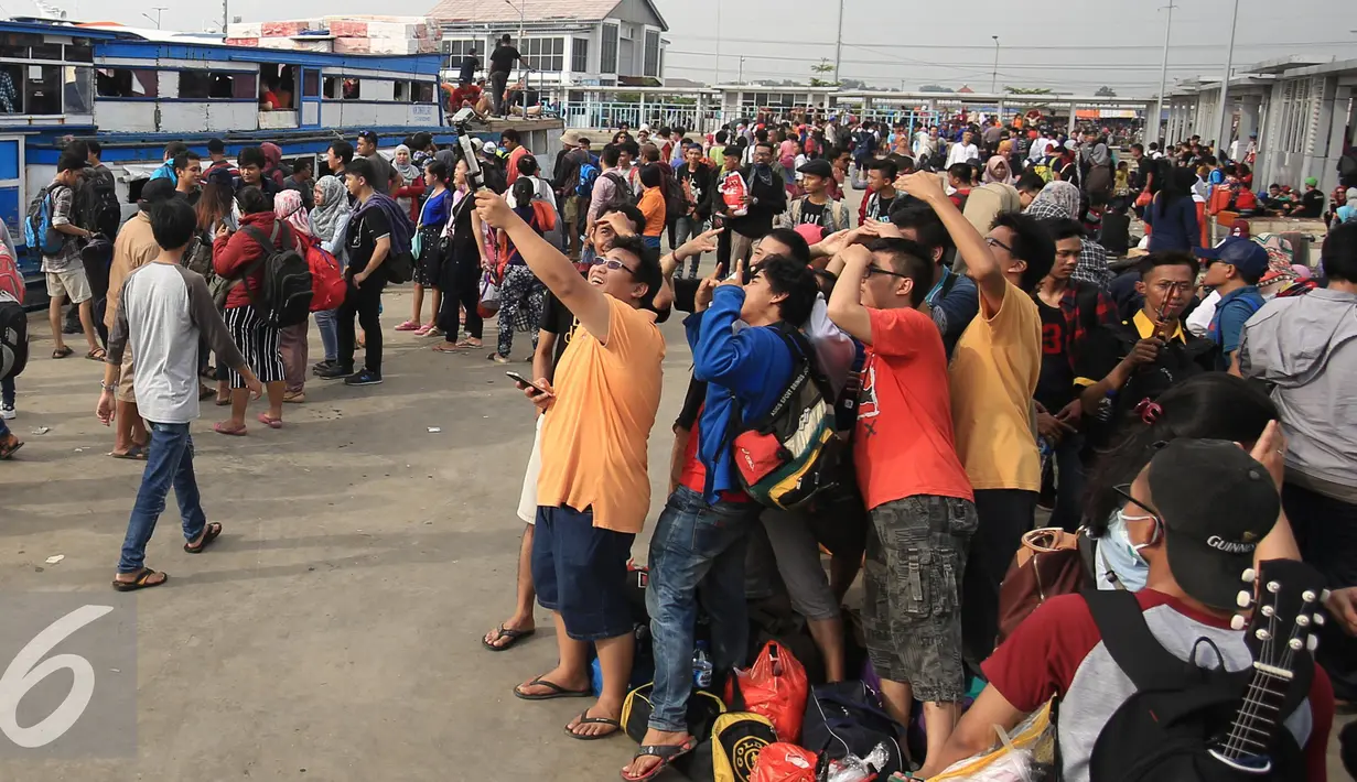 Warga berselfie saat menunggu kedatangan kapal di Pelabuhan Kali Adem, Jakarta, Kamis (5/5). Ratusan masyarakat tersebut akan menikmati libur panjang di Kepulauan Seribu. (Liputan6.com/Angga Yuniar)