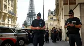 Petugas polisi berkumpul di sebuah jalan dekat Menara Eiffel jelang malam upacara pembukaan Paralimpiade Paris 2024, Selasa, 27 Agustus 2024 di Paris. (AP Photo/Thomas Padilla)