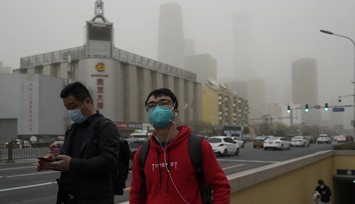<p>Warga berjalan di jalan saat badai debu melanda Beijing, Jumat, 10 Maret 2023. Beijing sebelumnya terkenal karena kualitas udaranya yang buruk, tetapi kondisinya telah jauh lebih baik dalam beberapa tahun terakhir karena pihak berwenang mengambil kendaraan yang sangat berpolusi dari jalan dan memindahkan pembangkit listrik tenaga batu bara dan industri berat ke provinsi sekitarnya. (AP Photo/Ng Han Guan)</p>
