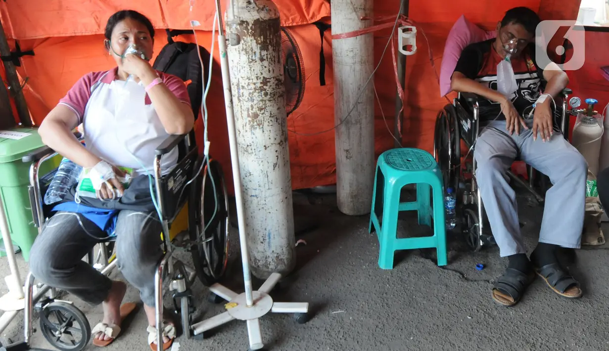 Pasien COVID-19 menjalani perawatan di dalam tenda darurat di RSUD Kota Bekasi, Jawa Barat, Jumat (25/06/2021). Puluhan pasien covid-19 saat ini dirawat dalam tenda darurat karena keterisian tempat tidur yang penuh akibat lonjakan kasus. (merdeka.com/Arie Basuki)