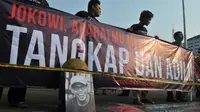 Spanduk berisi tuntutan penuntasan kasus pelanggaran HAM dibentangkan saat aksi kamisan di depan Istana Negara, Jakarta, Kamis (2/7/15). Dalam aksinya mereka meminta kepada Jokowi untuk menuntaskan kasus pembunuhan Jopi. (Liputan6.com/Herman Zakharia)