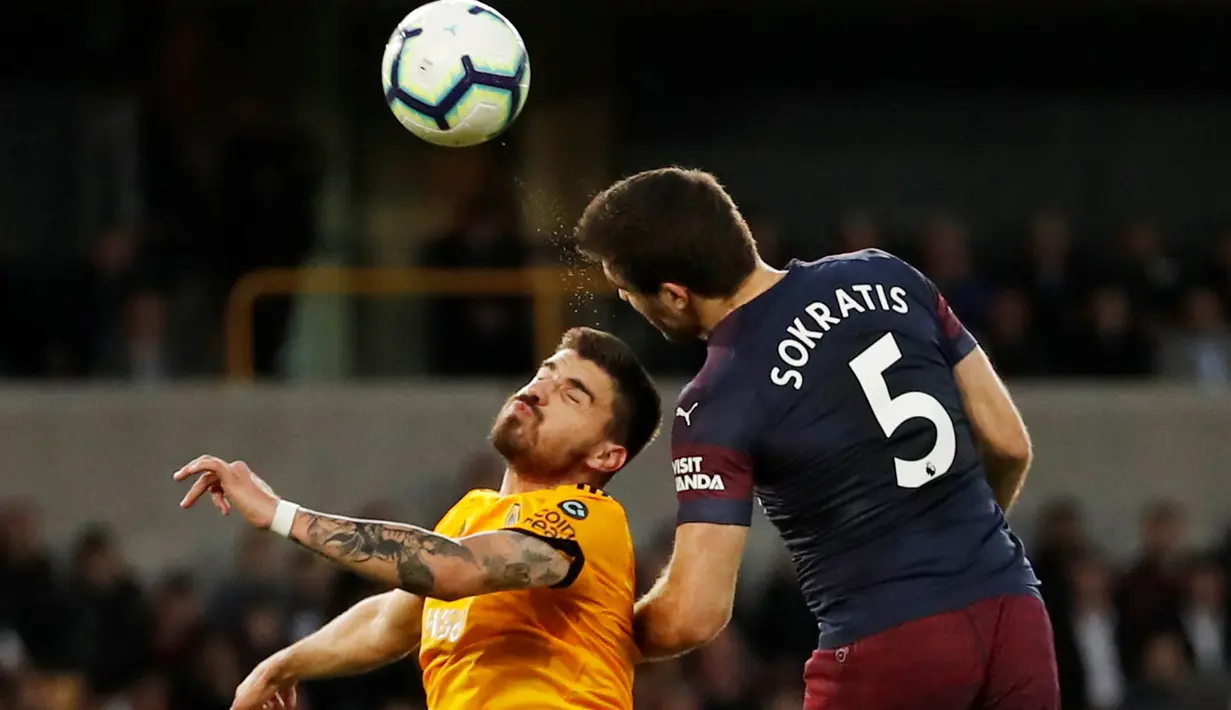 Duel udara pemain Wolverhampton Wanderers, Ruben Neves dengan bek Arsenal, Sokratis Papastathopoulos pada laga lanjutan Liga Inggris 2018-2019 di Stadion Molineux, Rabu (24/4). Arsenal harus tumbang dengan skor 1-3 kala bertandang ke markas Wolverhampton Wanderers. (REUTERS/ Andrew Boyers)
