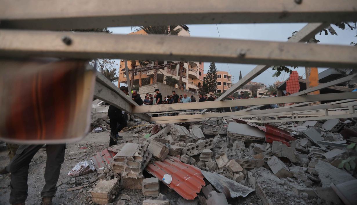 Serangan ini memicu kepanikan warga dan menambah panjang daftar pelanggaran yang dilakukan Israel terhadap gencatan senjata yang ada. Tampak dalam foto, orang-orang memeriksa lokasi bangunan yang hancur akibat serangan udara Israel di desa Teir Debba, Lebanon Selatan, Kamis 6 November 2025. (AP Photo/Mohammad Zaatari)