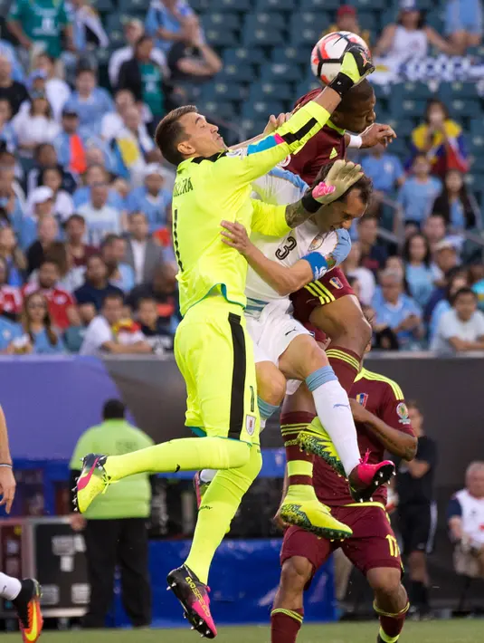 Kiper Uruguay, Fernando Muslera berusaha menangkap bola dari kejaran penyerang Venezuela,  Jose Salomon Rondon pada Copa America  Centenario 2016 di Lincoln Financial Field, AS (10/6). Venezuela menang atas Uruguay 1-0. (Bill Streicher-USA TODAY Sports)