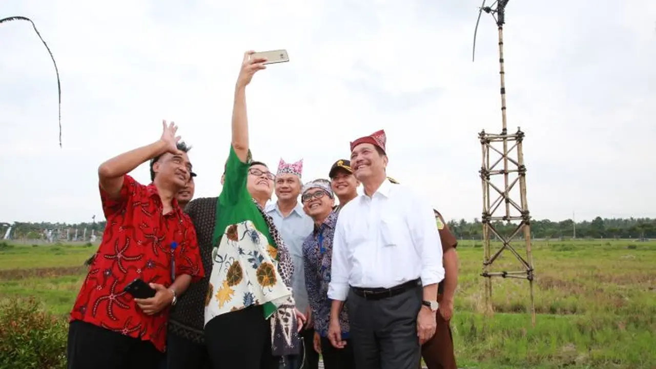 Menko Maritim Luhut Binsar Pandjaitan, Menkeu Sri Mulyani Indrawati, dan Gubernur BI Agus Martowardojo berfoto bersama di Bandara Banyuwangi. (Dian/Liputan6.com)