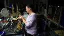 Pekerja mengecek bagian key finger button pada saksofon di pabrik Selmer Saxophone di Mantes-la-Ville (17/1). Saxophone berasal dari Belgia, dibuat oleh seorang pemain clarinet dan pembuat alat musik bernama Adolphe Sax. (AFP Photo/Alain Jocard)