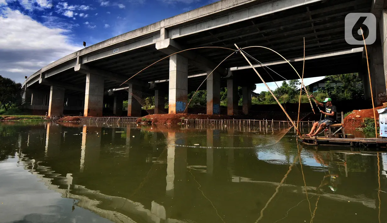 Warga menangkap ikan dengan jaring apung di bawah jalan Tol Serpong-Cinere, Setu Sasak Tinggi, Pamulang, Tangerang Selatan, Banten (6/4/2021). Setu Sasak Tinggi dimanfaatkan warga menangkap ikan mujair. (merdeka.com/Arie Basuki)